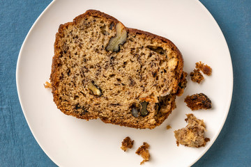 slice of banana bread with walnuts on a white plate, dessert concept