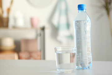Clear water in a glass and bottle on the table