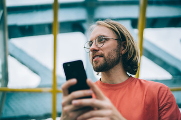 Confident male using cellphone in pedestrian crossing