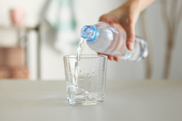 Clear water in a glass and bottle on the table