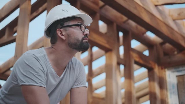 A man is building a house and working on a project, making a drawing.