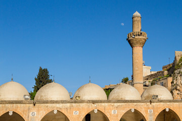 Domes and minaret of the mosque from the courtyard near the cave where it is believed Prophet Abraham was born, in Sanliurfa, Turkey.