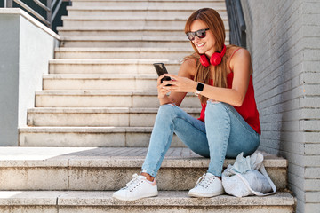 Fototapeta premium Young woman using her mobile phone in the city. Concept of new technologies and social networks.