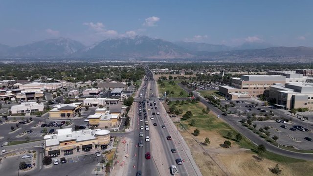 Aerial: Riverton city roads and hospital in Utah, Wasatch Range in background