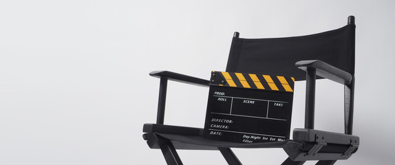 Director chair with black and yellow clapper board or movie slate on white background.it is used in...