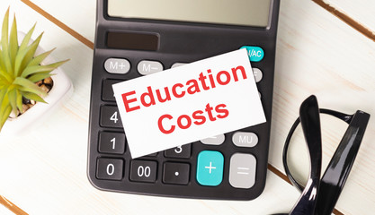 text of education costs written on notepad, with calculator and calculations.