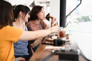 Group of young Asian woman hangout together at cafe, Friendship lifestyle eating and talking chitchat at coffee shop. 