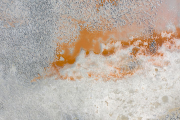 Salt with orange streaks of water on the surface of the salt lake. Texture. The view from the top.