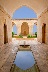 Ancient theological school known as Zinciriye Madrasa and reflection in its shallow pool in its...
