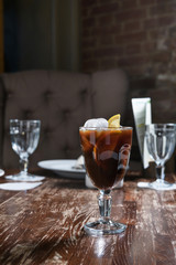 coffee with ice and lemon on a wooden table