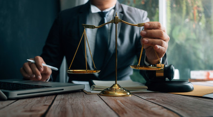 Business and lawyers discussing contract papers with brass scale on desk in office. Law, legal services, advice, justice and law concept