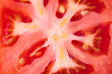 Close up of a slice of tomato, raw red fruit macro, abstract background, pattern.