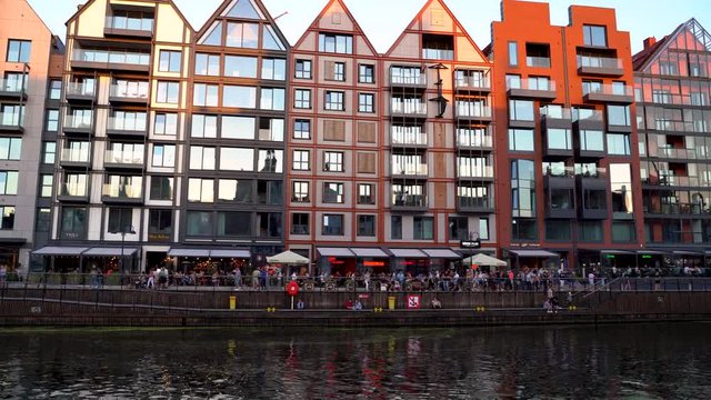 Gdansk, North Poland  Pan shot of Tourists walking on streets over a weekend at city center main square by motlawa river