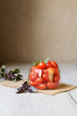 small cherry tomatoes lie on the table in a cup with purple basel
