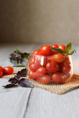 small cherry tomatoes lie on the table in a cup with purple basel
