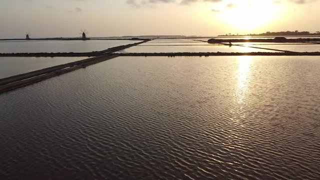 Flying Over The Salines With Sunset Reflection In Mazara Del Vallo Town In Trapani, Sicily, Italy. - low aerial drone shot