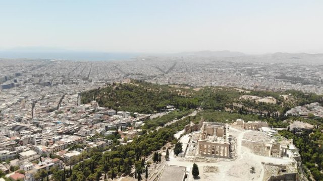 Aerial view of city of Athens along with Acropolis and Parthenon temple from above. Sunny day, Summer period. Athens, Greece.