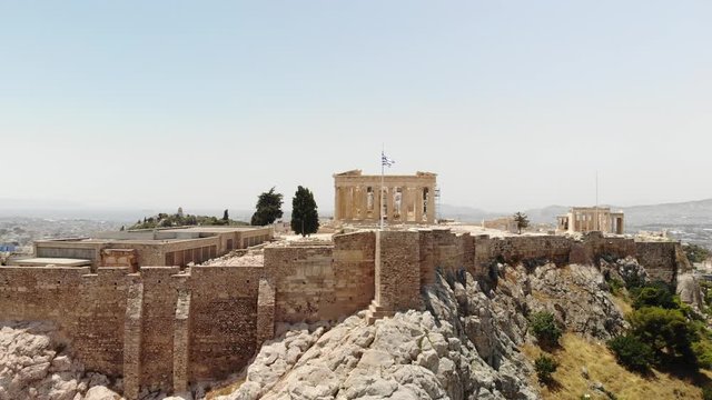 Greek flag waving in front of the Parthenon temple at the Acropolis of Athens, Greece.
