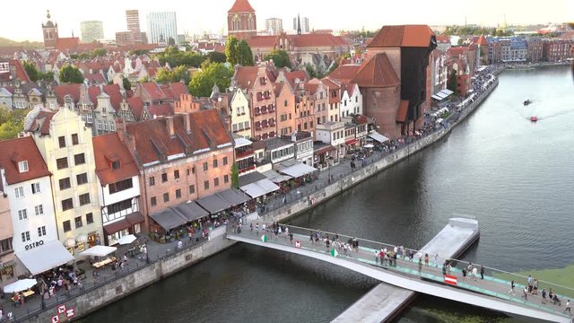 Gdansk, North Poland : aerial drone shot of Tourists walking on streets over a weekend at city center main square by motlawa river during beautiful sunset