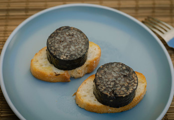 The Spanish Morcilla, blood sausage, over a bread.