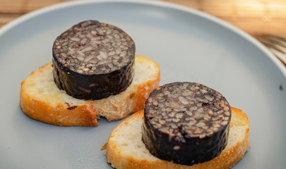 The Spanish Morcilla, blood sausage, over a bread.