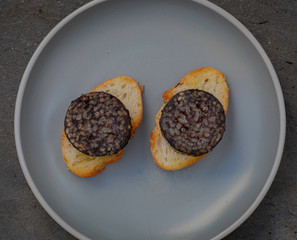 The Spanish Morcilla, blood sausage, over a bread.