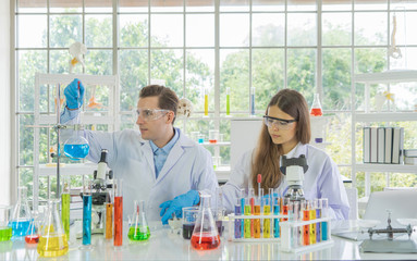 A western scientists couple working on test tube to analysis and develop vaccine of covid-19 virus...