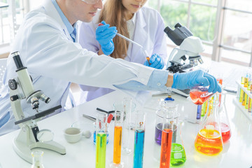 A western scientists couple working on test tube to analysis and develop vaccine of covid-19 virus...