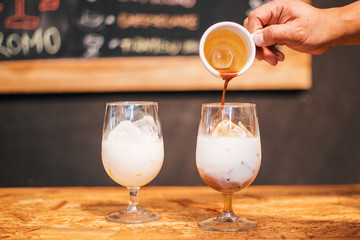 Mano de barista sirviendo café en un latte