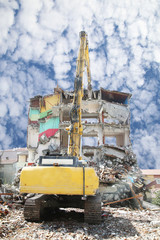 a high reach demolition excavator demolishing building. a big excavator working demolishing site. 