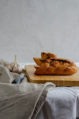 Fototapeta na wymiar Loaf of white bread with garlic on a wooden board. Sliced white bread