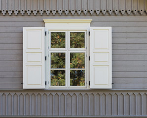 White wooden window with shutters on a gray wall background