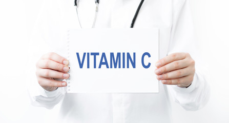 Doctor holding a card with Vitamin C, Medical concept