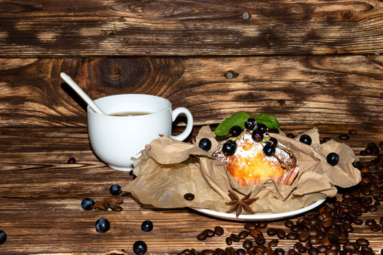 Mafin of wheat flour in a package of brown paper. Cupcakes decorated with fruit. Fresh home cupcake on a wooden background.
Natural ingredients. We cook at home. Beautiful appetizing background