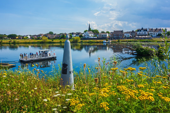 View of Eijsden, Netherlands with ferry and border marker seen from Belgian side of the river
