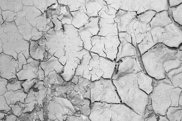 Peeling paint on the wall. Old concrete wall with cracked flaking paint. Weathered rough painted surface with patterns of cracks and peeling. Grunge texture for background and design. High resolution.