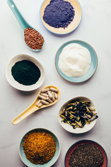 Variety of healthy food supplements such as blue matcha, butterfly pea flowers, collagen powder, spirulina powder, vitamins for vegans and vegetarians, flax and chia seeds,