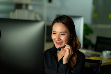 employee customer service representative working as technical support call center in the office with headphone computer overtime in the night