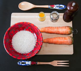 Vista cenital de un tazón de arroz blanco sin cocinar junto a un par de frescas y orgánicas...