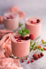 Glasses of berry smoothie with fresh mint on dark background.