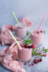 Glasses of berry smoothie on light background.