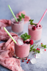 Glasses of berry smoothie with fresh mint on dark background.