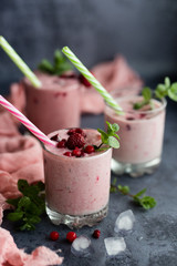 Glasses of berry smoothie on dark background.