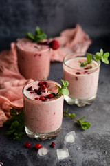 Glasses of berry smoothie on dark background.
