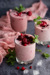 Glasses of berry smoothie on dark background.