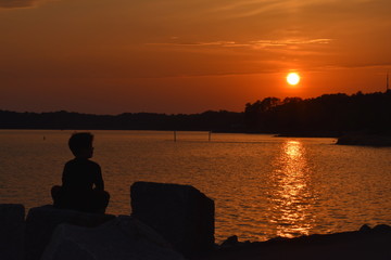 Fototapeta na wymiar silhouette orange sunset over lake