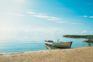 Obraz premium White wooden boat on the lake.