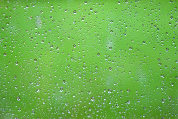 Fototapeta na wymiar Water drops dripping on glass of window after rain