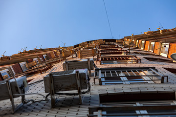 Multi-storey residential building. The front of the house is hung with air conditioning and satellite dishes. Bottom view