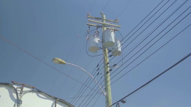 Montreal, Canada - June 5, 2018: The electric pole and electric transformer against the clear blue sky. High power electrical cabling system